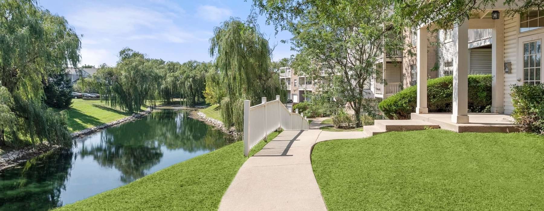 a sidewalk near a pond